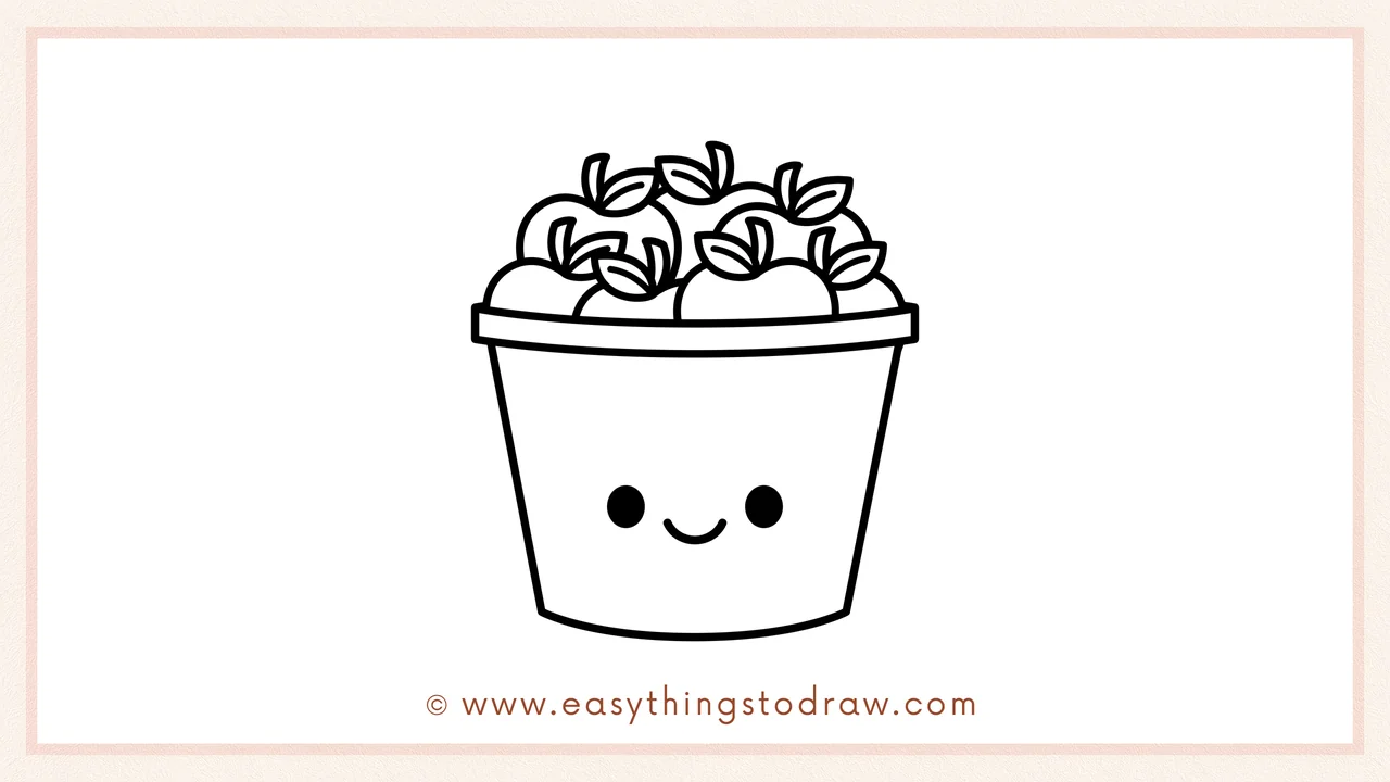 Step 6 of simple bucket of apples drawing tutorial – Adding two round eyes and a smiling mouth to the bucket's front.