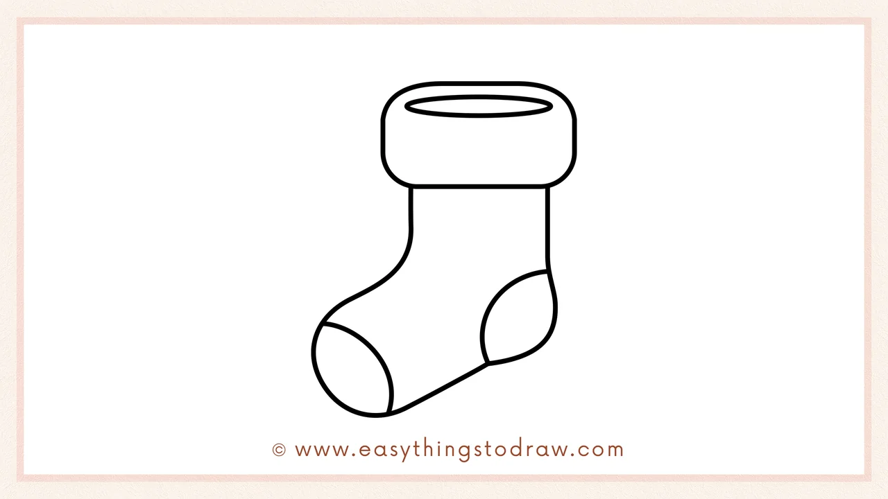 Step 5 of easy Christmas stocking drawing steps – drawing a small curved shape at the front for the toe patch.