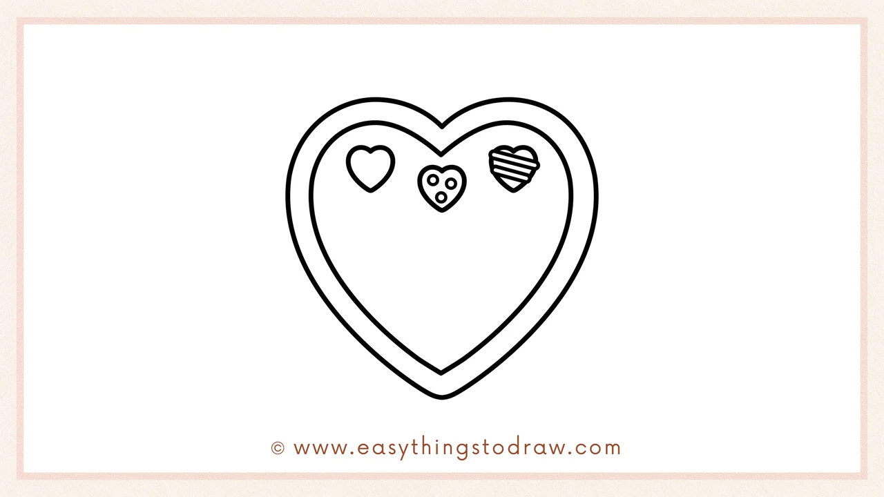 Step 3 of sketching a Valentine's Day box of chocolates for beginners – Drawing three small heart-shaped chocolates at the top of the box.