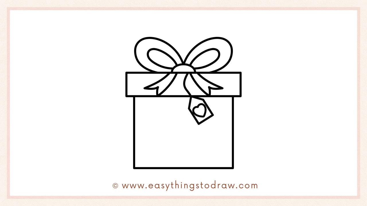Step 5 of easy Valentine's Day Gift drawing steps – sketching a small gift tag with a little heart inside, hanging from the bow.