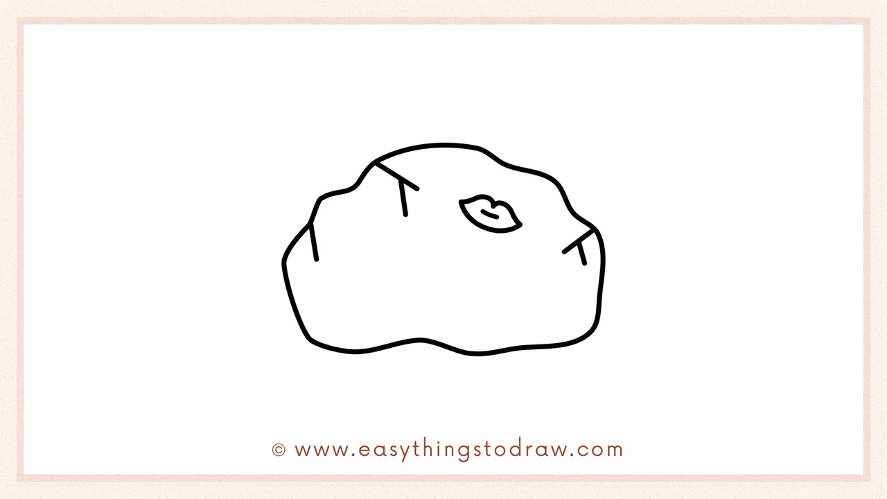 Step 5 of easy blarney stone drawing steps – sketching a small leaf resting on the top of the rock.